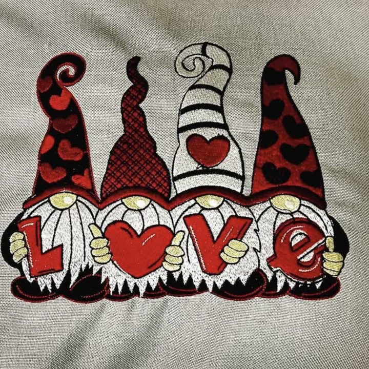 Výšivka čtyř skřítků s nápisem Love na polštáři
